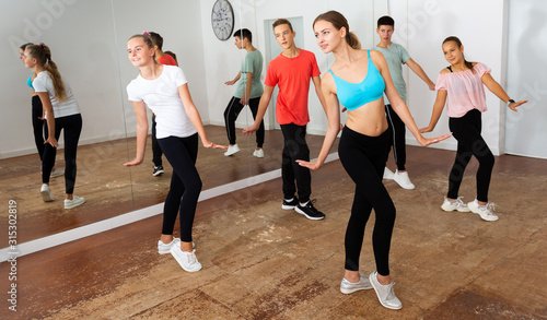 Teens practicing dance with female trainer