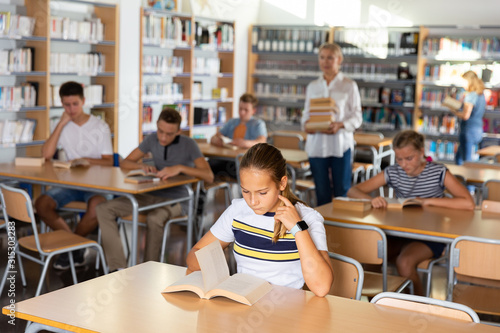 Students reading books in  library