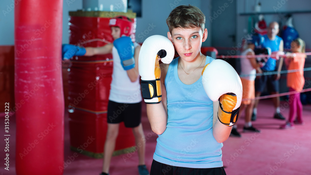 Portrait of  boy boxer wearing gloves at boxing hall