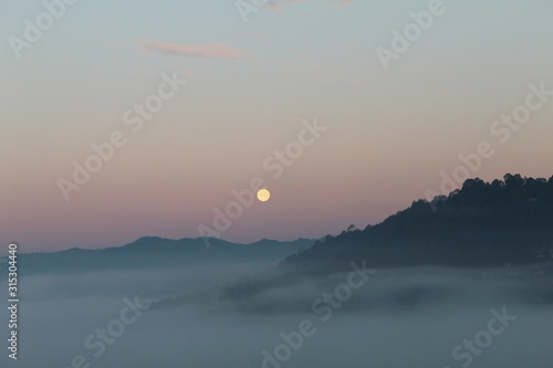 red moon above the mountain with fog