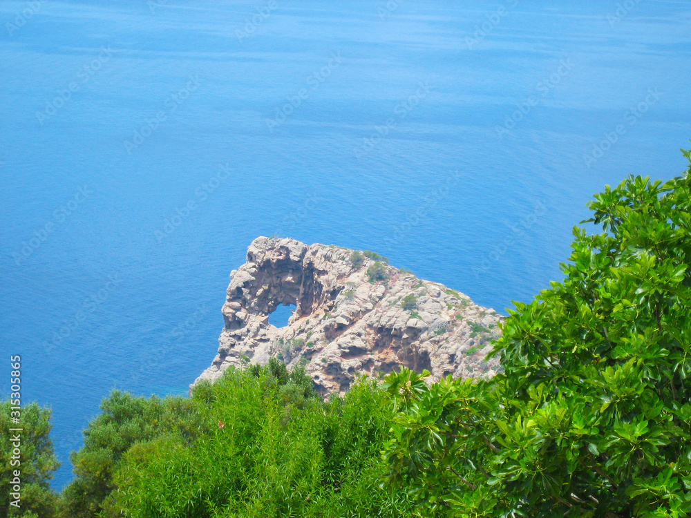 Felsen Na Foradada mit einem Loch in der Felswand, Hintergrund das Mittelmeer, Mallorca, Balearen, Ausflugsziel, Küste, Urlaub, Reisen, mediterran, Sommer, Sonne, Steilküste, Küstenstreifen, Bucht