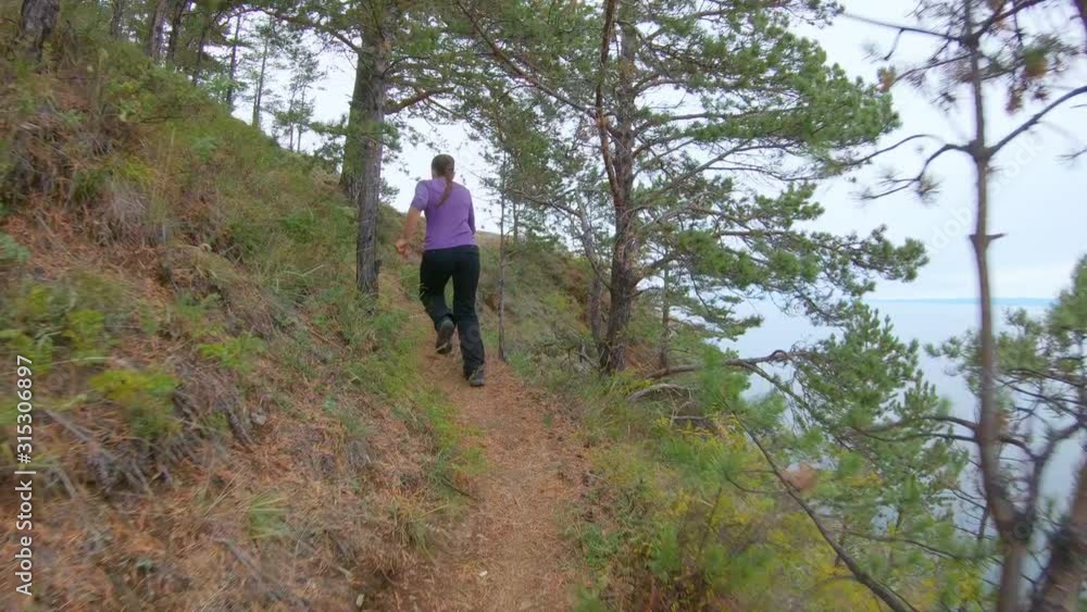 Girl runs up the mountain with a beautiful view, jumps up and throws her hands up. Follow shot Girl runs up the mountain with a beautiful view, jumps up and throws her hands up. Follow shot