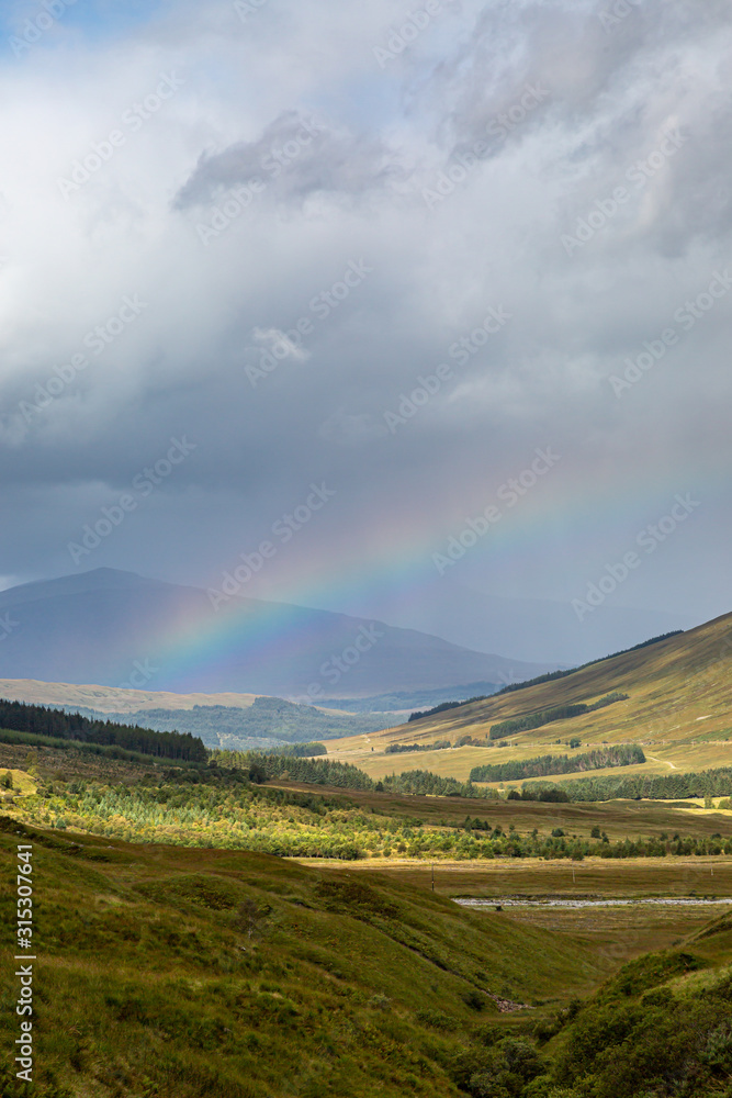 Obraz premium A Rainbow and Mountains in Scotland on a September Day
