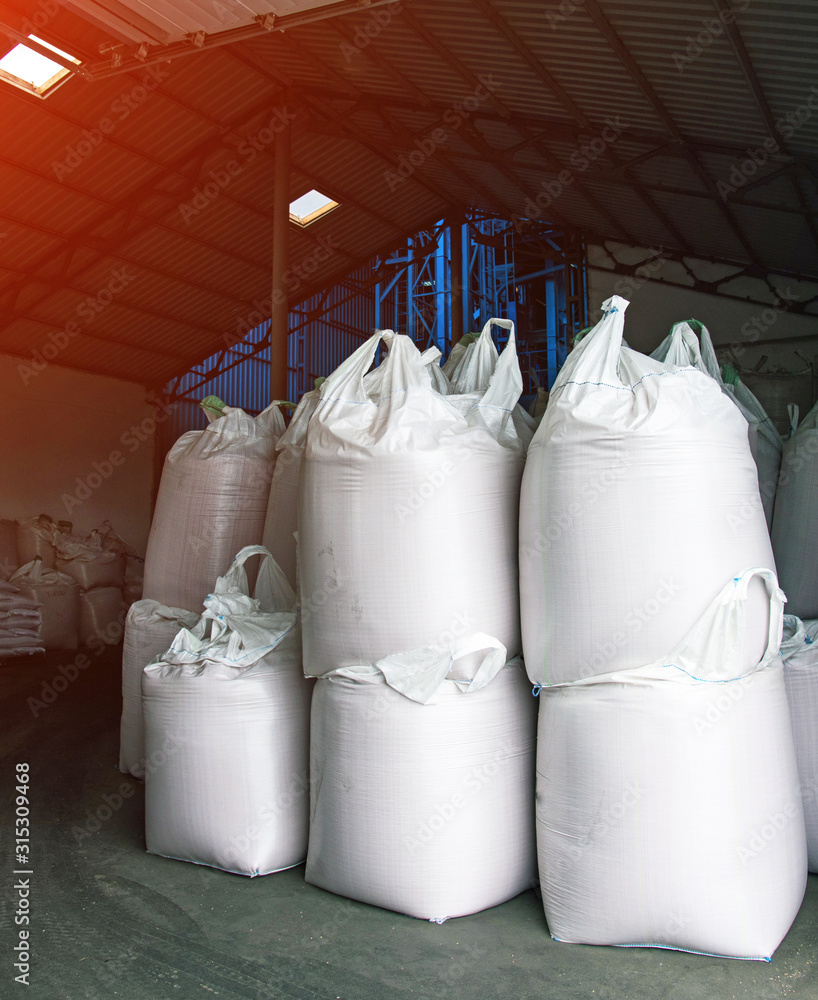 Abstract agrarian image with bags of grain in the agricultural sector in the farm. (good harvest, abundance - concept)