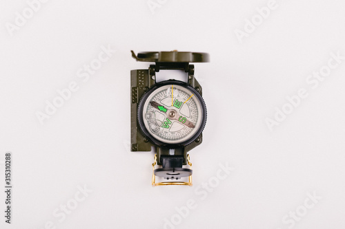 metal navigation travel compass on a light gray background. search for a way. point of view