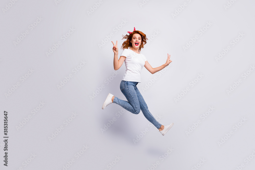 Full length body size view of her she nice attractive lucky cheerful cheery girl jumping wearing casual clothes having fun showing v-sign isolated over light white pastel color background