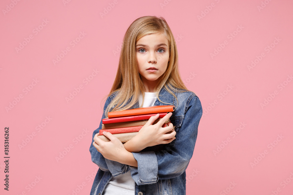 Beautiful little blonde kid girl 12-13 years old in denim jacket isolated on pastel pink background children studio portrait. Childhood lifestyle concept. Mock up copy space. Holding books, notebooks. Beautiful little blonde kid girl 12-13 years old in denim jacket isolated on pastel pink background children studio portrait. Childhood lifestyle concept. Mock up copy space. Holding books, notebooks.