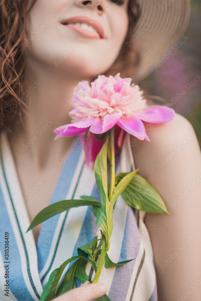 A girl with tenderness peonies bouquet on the vintage wall background