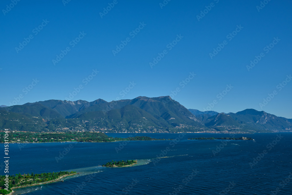 Naklejka premium Panoramic view of the island of San Biagio, Italy. Lake Garda, blue sky