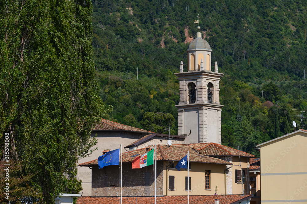 Caritas Zonale Church is a city of Salo, Italy. Lake Garda, blue sky, mountains, European flags