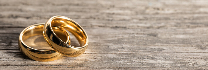 Golden wedding rings on wood