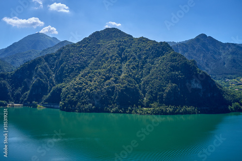 Wallpaper Mural Panoramic view of the mountains and Lake Idro. Autumn season, the reflection in the water of the mountains, trees, blue sky. Aerial view, drone photo Torontodigital.ca
