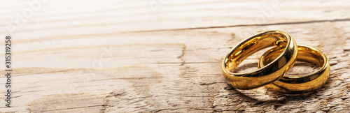 Fotografia, Obraz Golden wedding rings on wood
