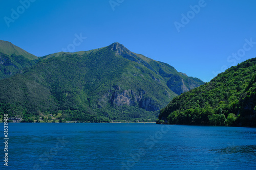 Panoramic view of the lake Ledro. Blue lake, green mountains, blue sky © Berg