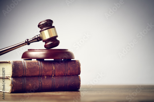 Photo Judge gavel and law books in court background with copy space