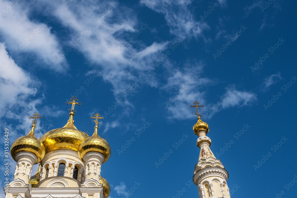 Golden domes of the Cathedral of St. Alexander Nevsky against the sky.