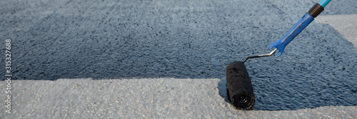 Konstfotografi Worker applies bitumen mastic on the foundation