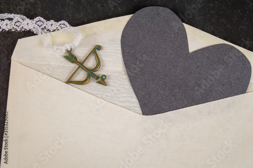 Black paper heart in white envelope.