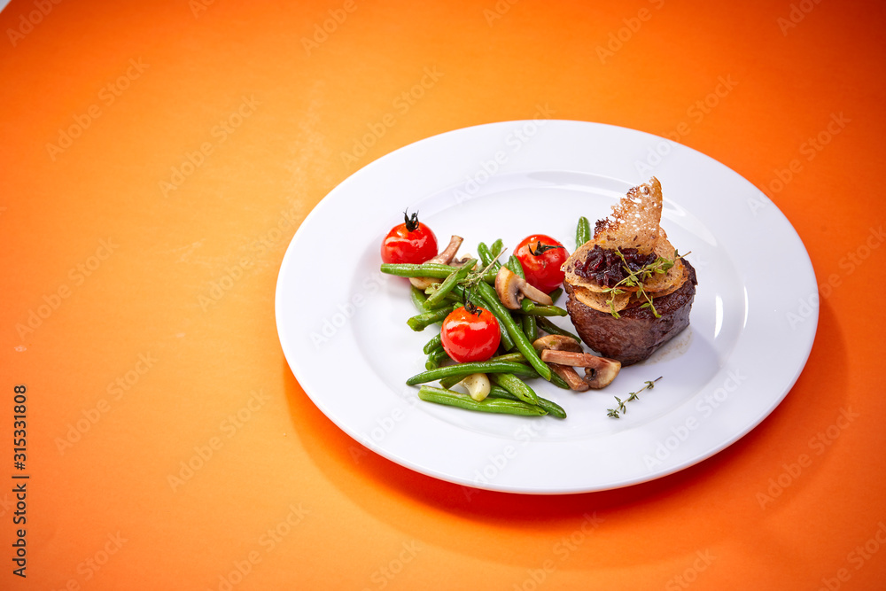 steak with vegetables on the orange background steak with vegetables on the orange background
