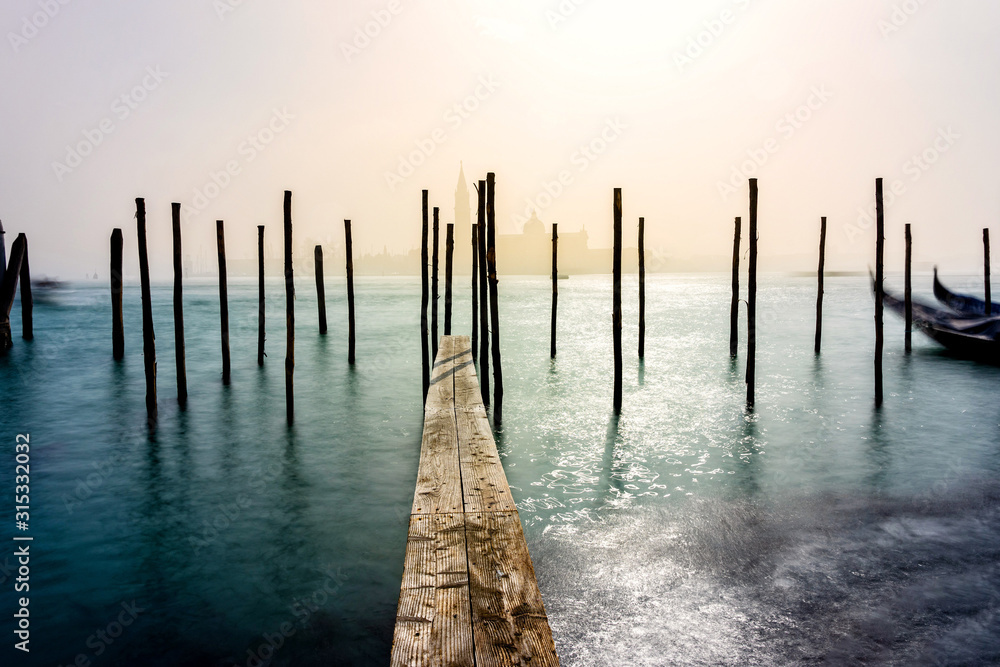 San Giorgio Maggiore church and wooden pier in Venice during a misty/foggy spring day, Venice, Italy.