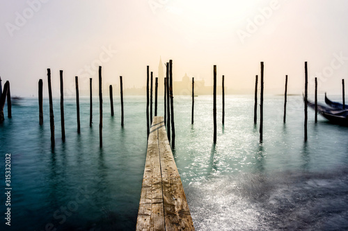 San Giorgio Maggiore church and wooden pier in Venice during a misty/foggy spring day, Venice, Italy. photo