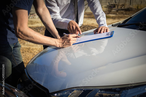 The customer signs the contract, agrees to acknowledge the agreement to claim damages From insurance agents for car crash accidents,traffic accident and insurance concept.