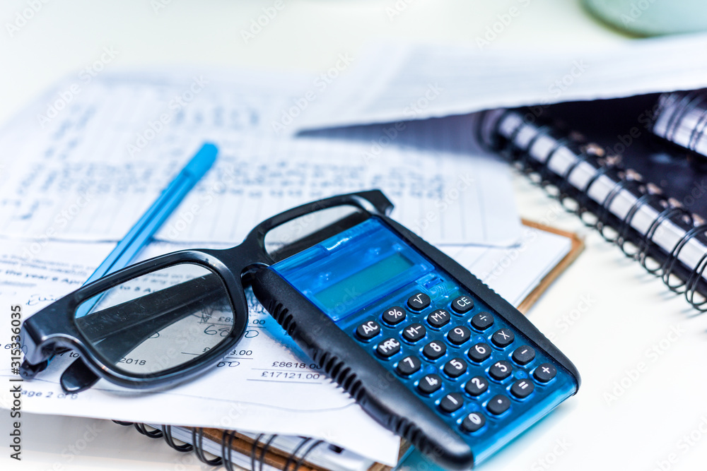 Calculating tax return numbers and figures on office desk concept for filling tax return forms Calculating tax return numbers and figures on office desk concept for filling tax return forms
