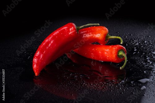 Three cayenne peppers in quaint form. Vegetable work of art. photo