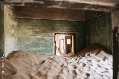 desert sand has invaded and taken over these rooms in Kolmanskoppe, Namibia photo