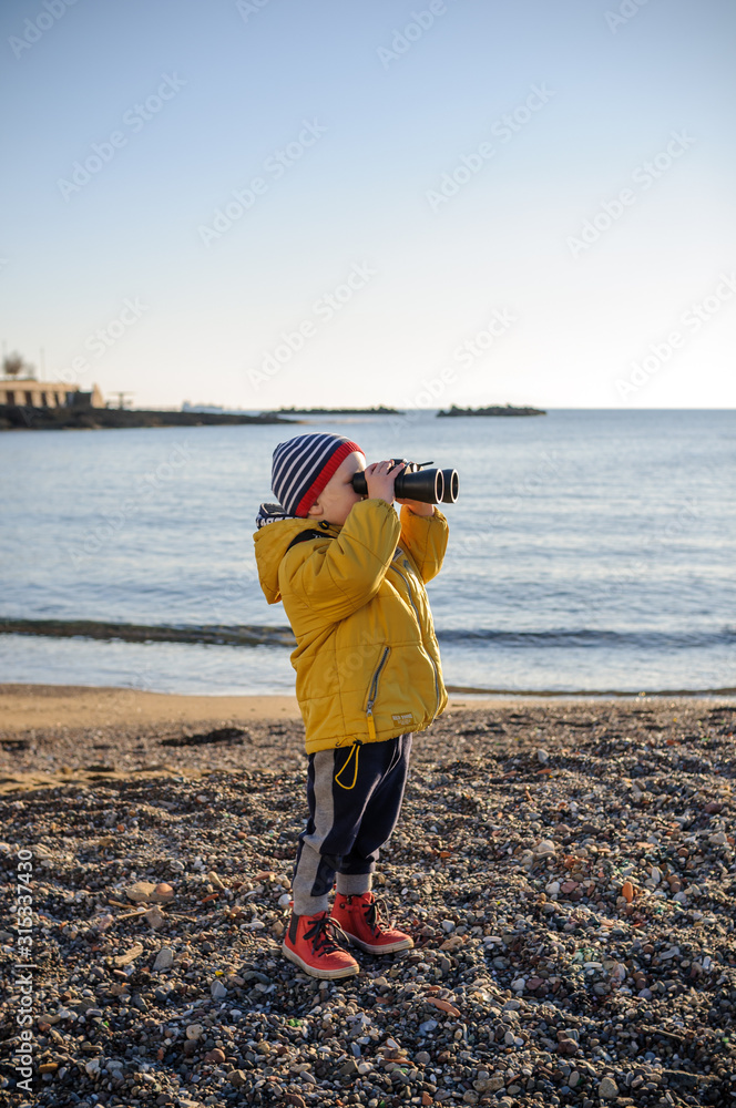 boy on the beach with binoculars
