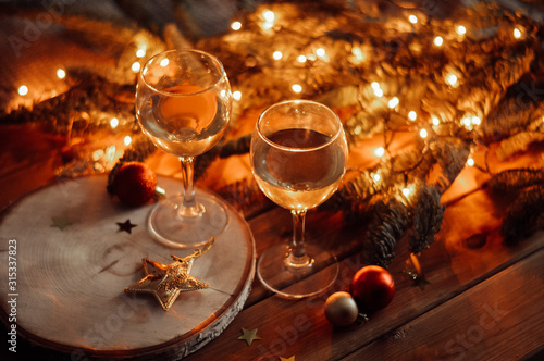 glass of white wine and garlad lights on the wooden background