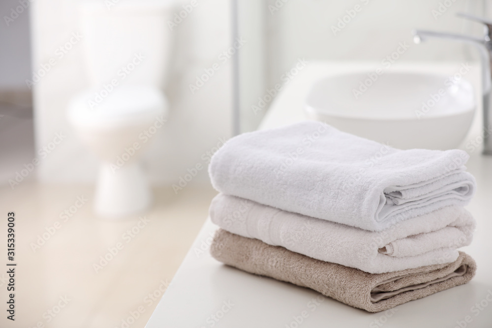 Stack of fresh towels on countertop in bathroom. Space for text Stack of fresh towels on countertop in bathroom. Space for text