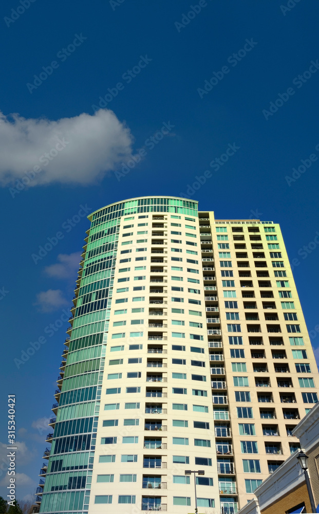 Condo Tower with Green Windows into Blue Sky