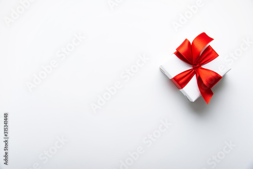 White gifts with red ribbon, present on white background top view. Happy Holidays. Valentine's day. Birthday. Women's day.