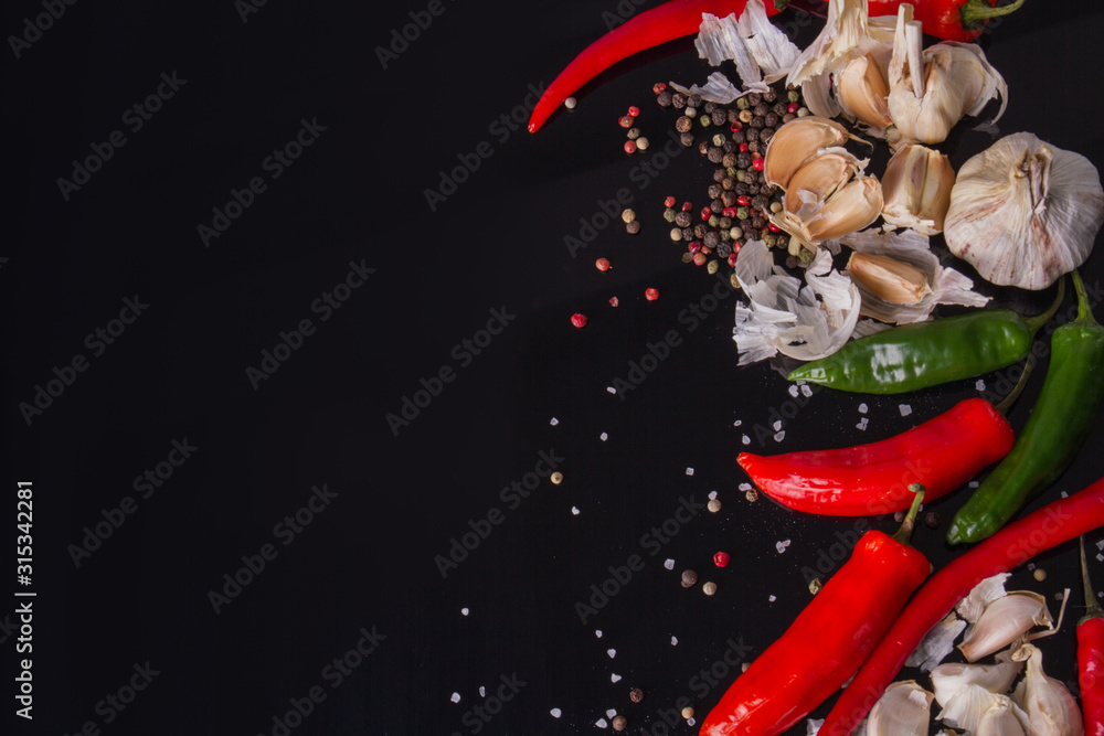 Allspice and green chili pepper. Hot flatlay in black space. Food concept.