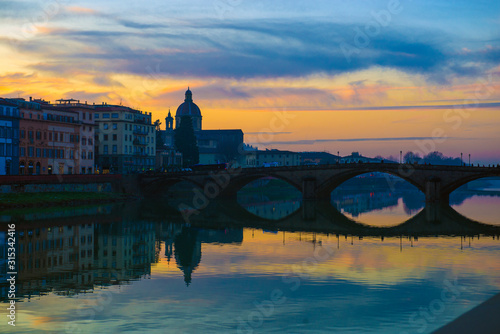 Florence, Ponte alla Carraia medieval Bridge landmark on Arno river at sunset. Tuscany, Italy.