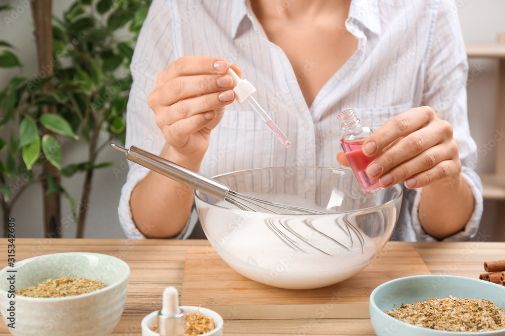 Woman making natural handmade soap at wooden table, closeup Woman making natural handmade soap at wooden table, closeup