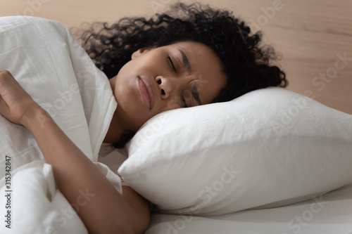 African woman lying in bed has nightmares sleeps bad photo