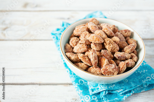 Fotografia caramelized almonds on white wooden surface