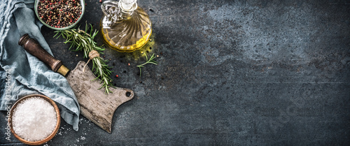 Obraz  z motywem Organic food concept with olive oil salt peppet rosemary and kitchen utensil - butcher knife