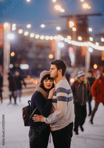 Young couple stands and embraces on the background city lights.
