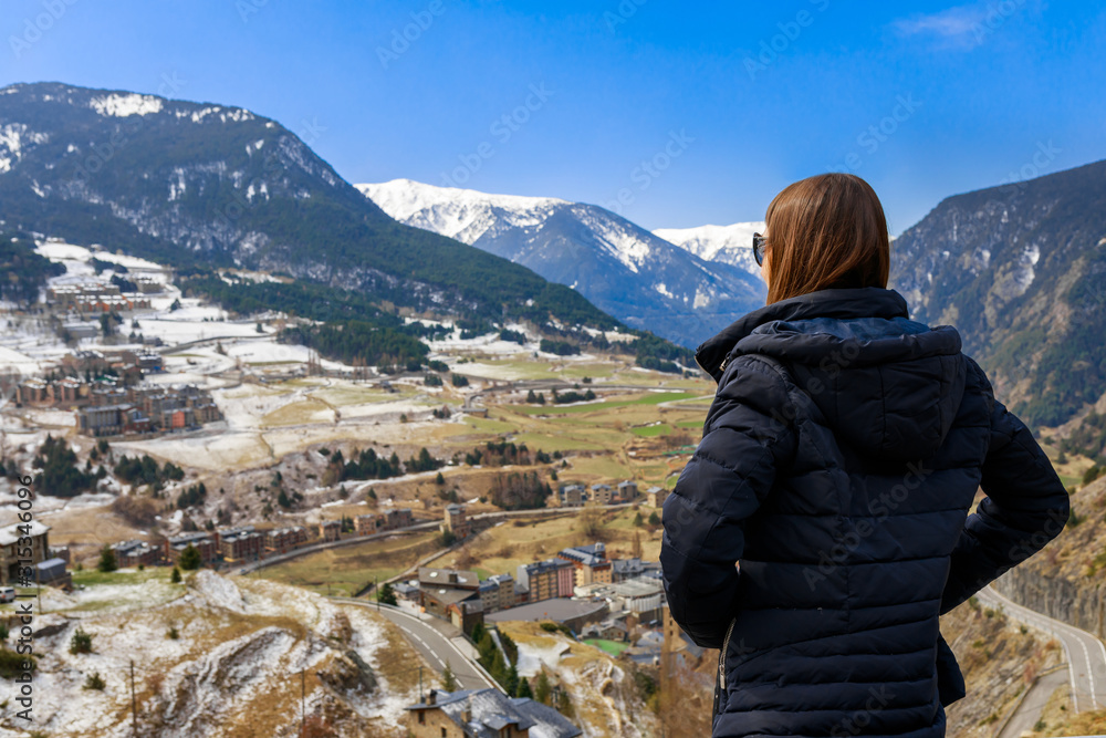 Young tourist woman and winter snow landscape mountain view in Andorra, Pyrenees mountains, Europe. Andorra is perfect tourist travel destination. Luxury amazing resort for skiing and winter travel