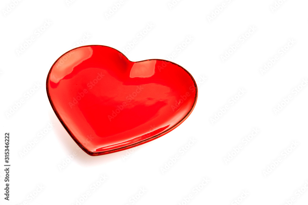 A red heart shape plate isolated on white background. Decoration for Valentine's day, wedding, birthday of any other love celebration. A red heart shape plate isolated on white background. Decoration for Valentine's day, wedding, birthday of any other love celebration.