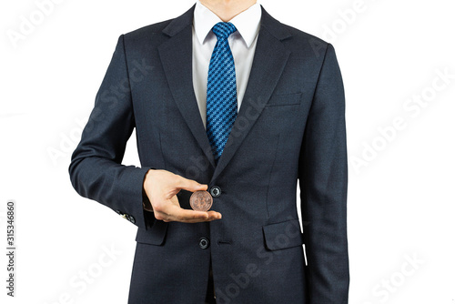 A person wearing a suit and holding a bitcoin in his hand.