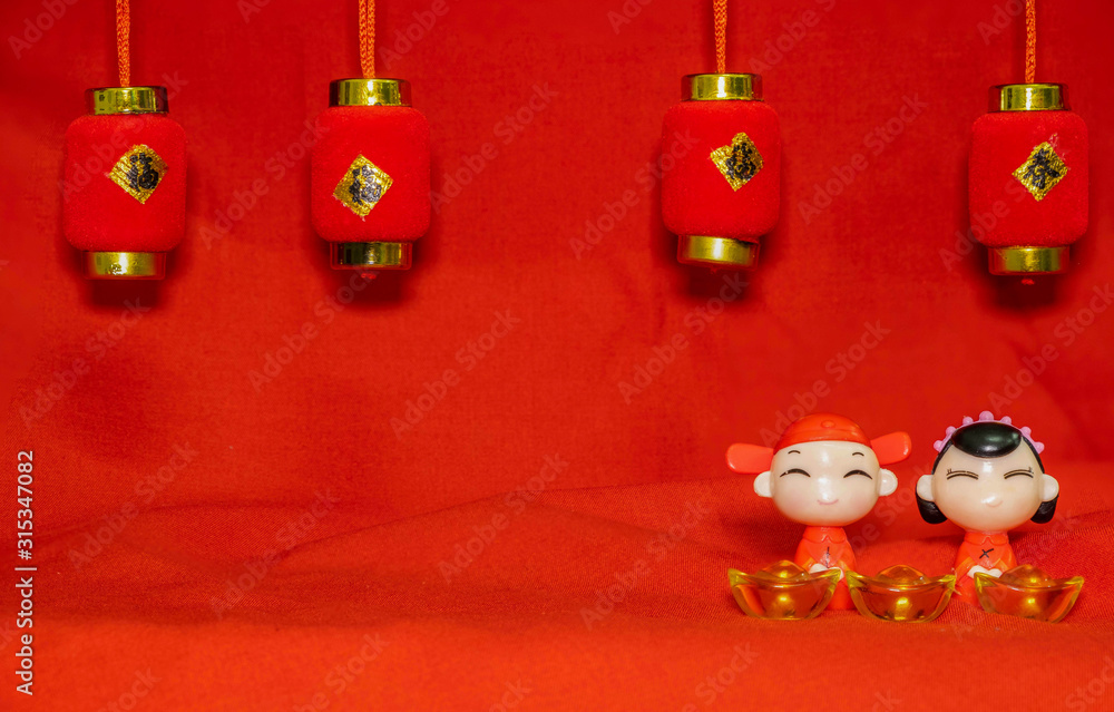 The Chinese New Year decoration on a red background Chinese Couple Figure Model wish for a Luck and lump of gold and a Chinese Word on Lantern said Luck The Chinese New Year decoration on a red background Chinese Couple Figure Model wish for a Luck and lump of gold and a Chinese Word on Lantern said Luck