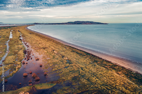 Фотография Aerial view over Bull Island shoreline revealing marram grass anchored dunes and view Howth on the horizon