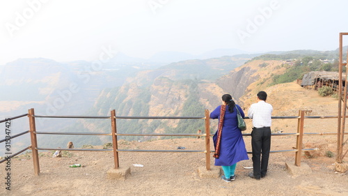 Lonavala, Maharastra/India- January 12 2019: A married couple looking at the valley from behind the railing. Holiday destinations in India.