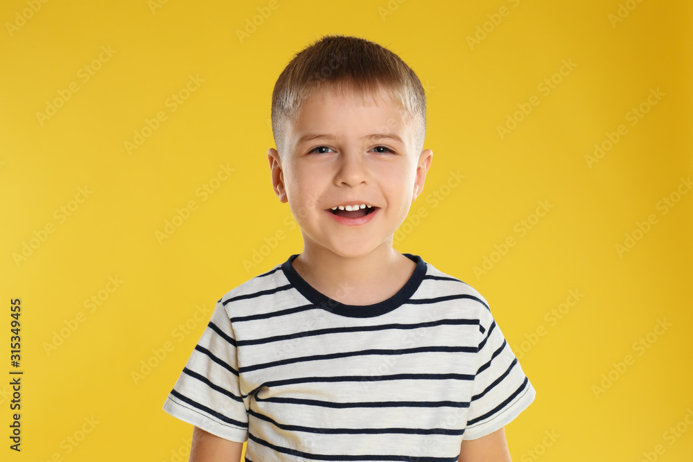 Portrait of happy little boy on yellow background Portrait of happy little boy on yellow background