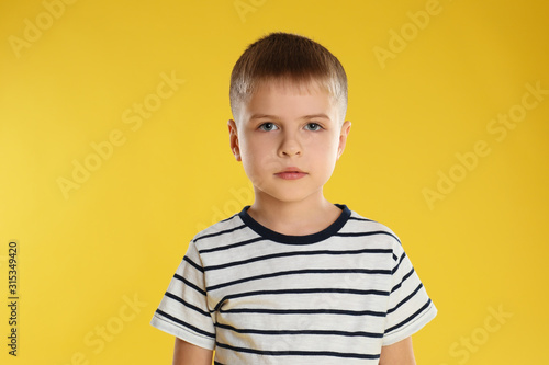 Portrait of little boy on yellow background