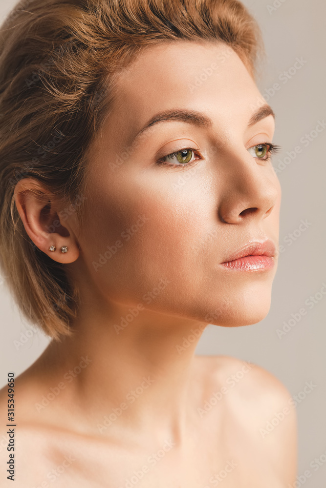 Naklejka premium beautiful girl with fair skin and green eyes. Face close up. Studio picture